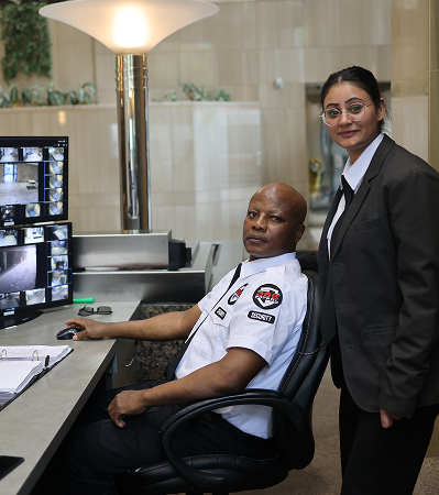 A team of security professionals monitoring CCTV screens at a control desk, a key component of our comprehensive security services.
