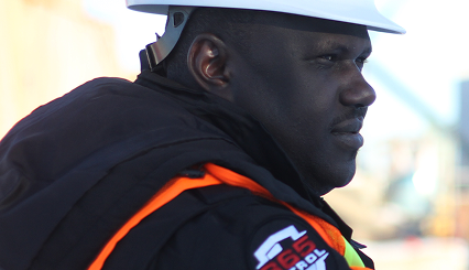 A security guard wearing a hard hat and safety gear, providing specialized industrial security services Calgary construction sites require.