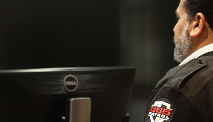 A 365 Patrol security officer monitoring surveillance feeds on a computer screen, providing attentive security services Calgary businesses trust.