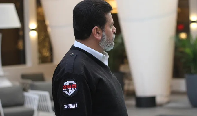 A professional security guard in a black uniform monitoring an upscale venue, representing the reliable security services Calgary businesses trust.
